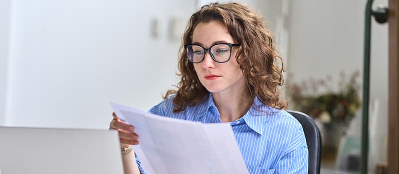 young-woman-working-from-home-looking-at-paperwork